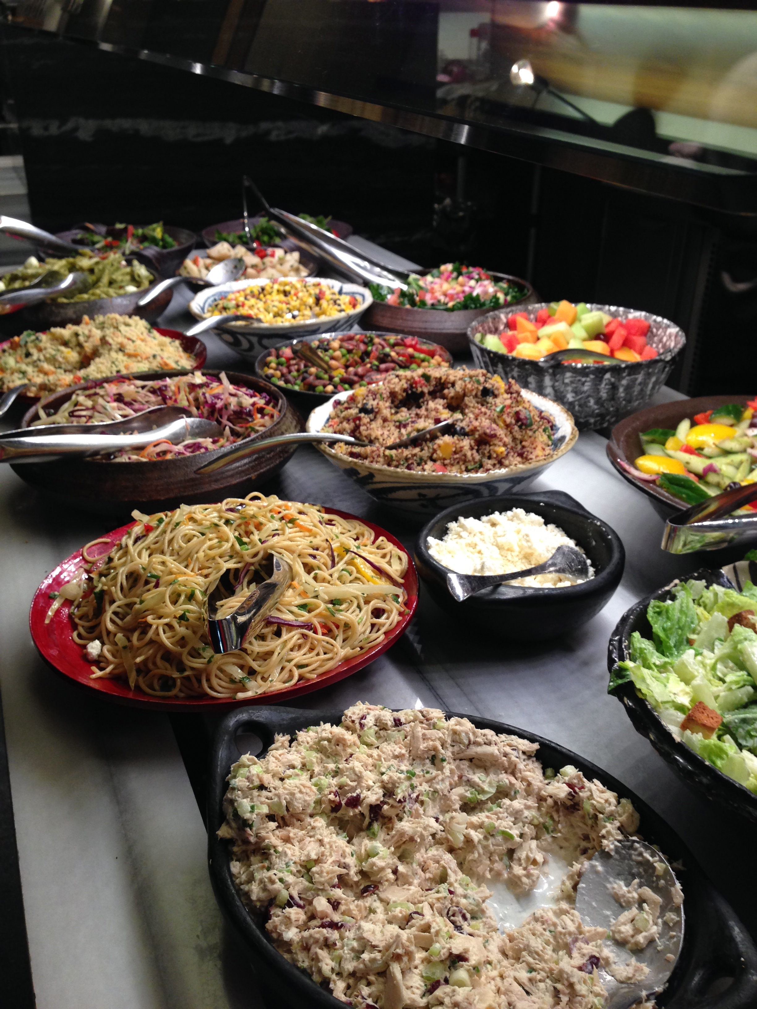 The large salad station with so many different and unique salads.