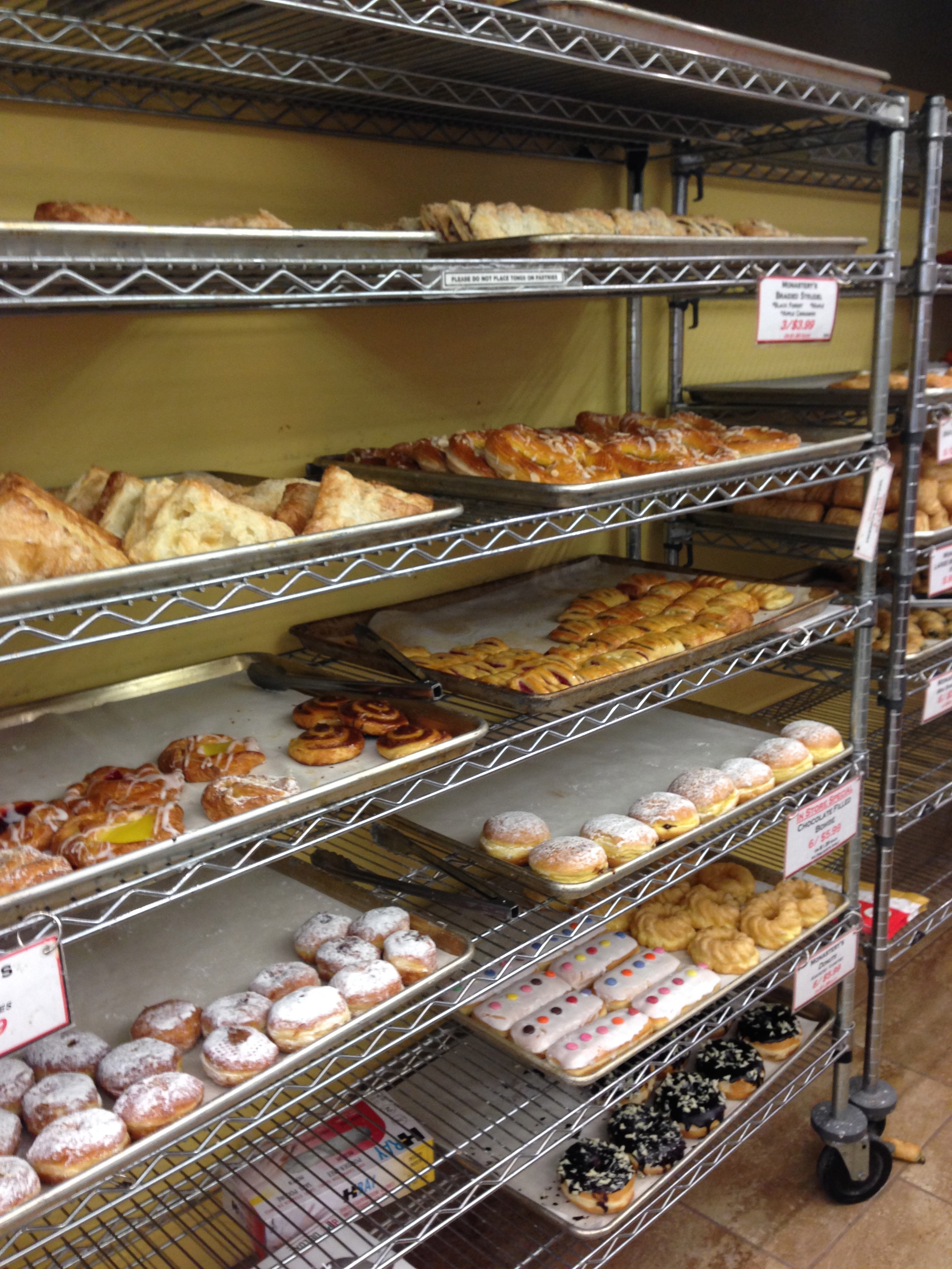 Racks of donuts and fruit turnovers.