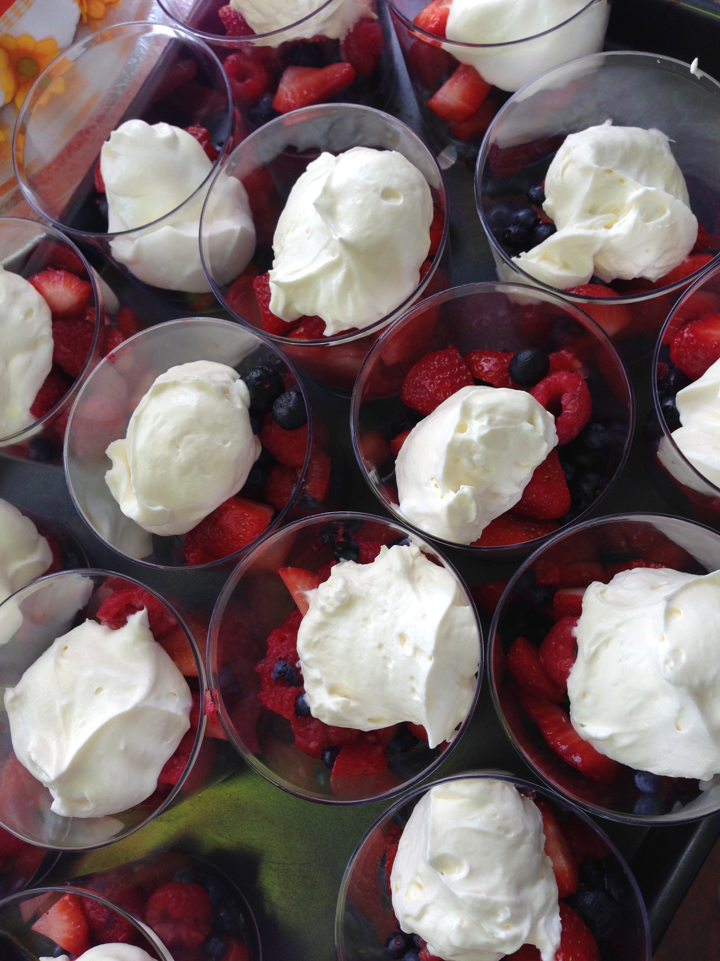 Dessert cups of fresh berries and fresh whip cream.